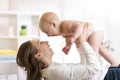 Mother and baby boy in diaper playing in sunny room. Parent and little kid relaxing at home. Family having fun together.