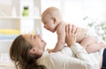 Mother and baby boy in diaper playing in sunny room. Parent and little kid relaxing at home. Family having fun together. Royalty Free Stock Photo