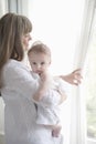 Mother With Baby Boy Looking Through Window Royalty Free Stock Photo