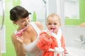 Mother with baby brushing teeth in bathroom Royalty Free Stock Photo