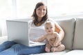 Mother and baby child are looking to play and read computer on the couch at home Royalty Free Stock Photo