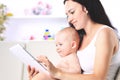 Mother and baby child are looking to play read tablet computer Royalty Free Stock Photo