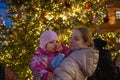 Mother and baby on christmas backgrouund street outdoors