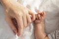 Mother Baby Connection. Newborn child holding mom& x27;s hand while lying in bed Royalty Free Stock Photo
