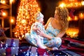 Mother and baby daughter having fun, playing together near Christmas tree in decorated living room Royalty Free Stock Photo