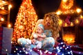 Mother and baby daughter having fun, playing together near Christmas tree in decorated living room Royalty Free Stock Photo