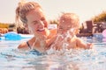 Mother With Baby Daughter Having Fun On Summer Vacation Splashing In Outdoor Swimming Pool Royalty Free Stock Photo