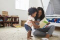 Mother And Baby Daughter Reading Book In Playroom Together Royalty Free Stock Photo