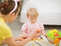 Mother and baby drawing on Easter eggs