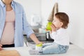 Mother and baby eating green apple at home kitchen Royalty Free Stock Photo