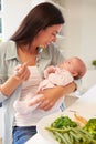 Mother With Baby Eating Healthy Meal In Kitchen Royalty Free Stock Photo