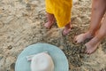 Mother and baby feet at the beach sand with hat. Summer travel with kid. Sunbathing concept Royalty Free Stock Photo