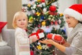 Mother and baby girl changing Christmas presents Royalty Free Stock Photo