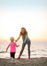 Mother and baby girl having fun time on beach Royalty Free Stock Photo