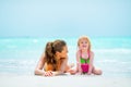 Mother and baby girl laying on beach Royalty Free Stock Photo