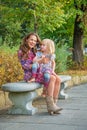 Mother and baby girl talking cell phone in park Royalty Free Stock Photo