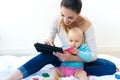 Mother and baby girl using digital tablet at home Royalty Free Stock Photo