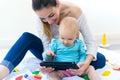 Mother and baby girl using digital tablet at home Royalty Free Stock Photo