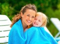 Mother and baby girl wrapped in towel on sunbed Royalty Free Stock Photo