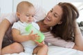 Mother with baby holding milk bottle on bed Royalty Free Stock Photo