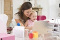 Mother and baby in home office with laptop Royalty Free Stock Photo