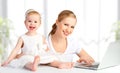 Mother and baby at home using laptop computer Royalty Free Stock Photo