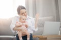 Mother and baby at home webcamera chatting looking at laptop. Concept family doctor online or social distance, blogger Royalty Free Stock Photo