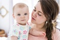 Mother and baby hugging at bedroom