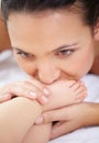 Mother, baby and kiss feet on bed for love, care and relax in nursery room at home. Face, mom and closeup of foot of Royalty Free Stock Photo