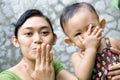 Mother and baby kiss goodbye