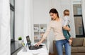 Mother with baby and laptop working at home