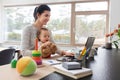 Mother with baby and laptop working at home office