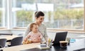 Mother with baby and laptop working at home office Royalty Free Stock Photo