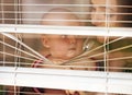 Mother with baby look through blinds. Woman and child at window shutters. Mothers day concept. Family love. Royalty Free Stock Photo