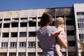 Mother with baby looking on burnt building of Mariuopl city hall Royalty Free Stock Photo