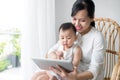 Mother and baby are looking to play and read tablet computer at Royalty Free Stock Photo