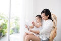 Mother and baby are looking to play and read tablet computer at Royalty Free Stock Photo