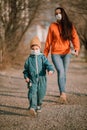 A mother with a baby in medical masks walks down the street during the coronavirus pandemic and Covid -19