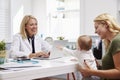 Mother And Baby Meeting With Female Doctor In Office Royalty Free Stock Photo