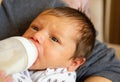 Mother and baby, mother feeds the baby, baby boy drinking a milk