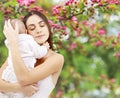 Mother with baby over spring garden background Royalty Free Stock Photo