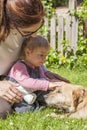 Mother and baby petting dog