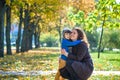 Mother and baby play in autumn park. Parent and child walk in the forest on a sunny fall day. Children playing outdoors with Royalty Free Stock Photo