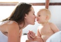 Mother and baby playing on bed