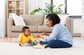 Mother and baby playing with toy blocks at home