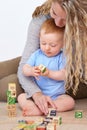 Mother, baby and playing with wooden blocks or toys for childhood development or bonding at home. Mom, toddler and Royalty Free Stock Photo