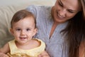 Mother, baby and portrait smile in relax of adorable and happy little girl sitting on mommy at home. Face of mama Royalty Free Stock Photo