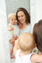 Mother and baby in reflection of mirror in bathroom Royalty Free Stock Photo