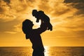 Mother and baby silhouettes at sunset on the sea beach Royalty Free Stock Photo