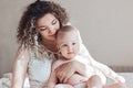 Mother and baby sitting on bed Royalty Free Stock Photo